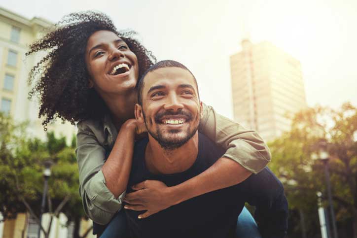 Couple outdoors smiling.