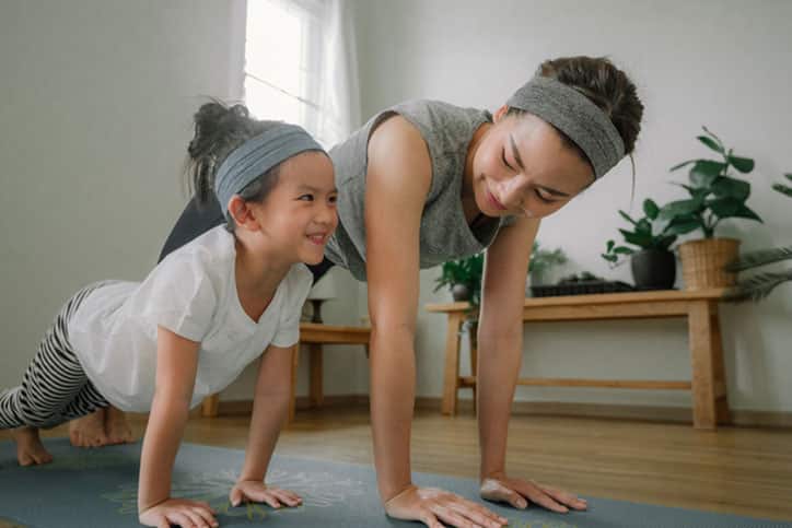 Sport young asian woman work out with little girl at home