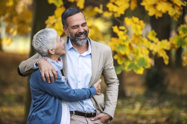 Woman Holding Man With Autumn Background