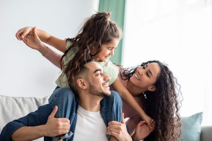 Parents Smiling with Daughter on Dad's Shoulders
